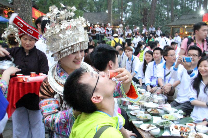 广西青年与香港青年在百家宴上互动，品尝特色美酒。（摄影：曹海扬）